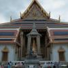 The Hermit Doctor, sitting in front of the rear-side of the Royal Chapel of the Emerald Buddha
